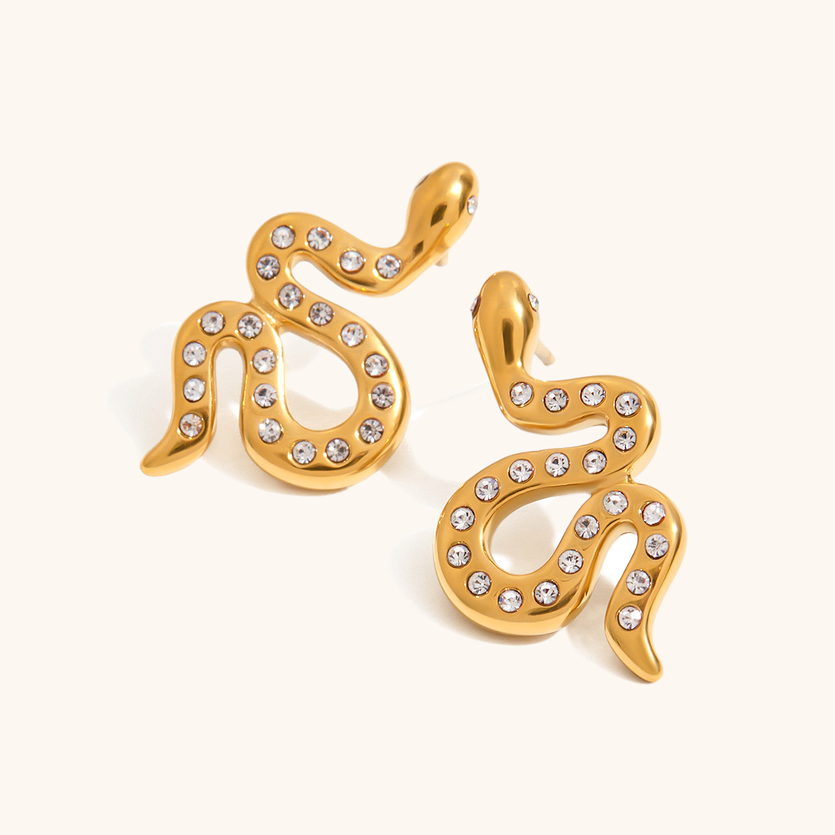 Bold gold snake-shaped earrings with crystal accents