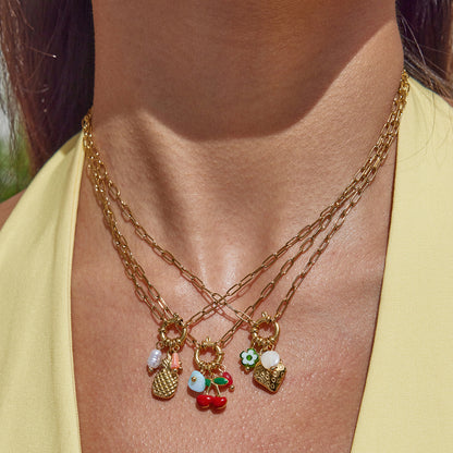 Gold necklaces with charms on a person wearing a yellow top.