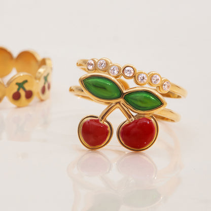 Stackable rings featuring red cherries and shimmering crystals