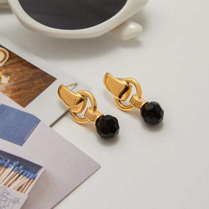 Waterproof black and gold earrings styled with sunglasses