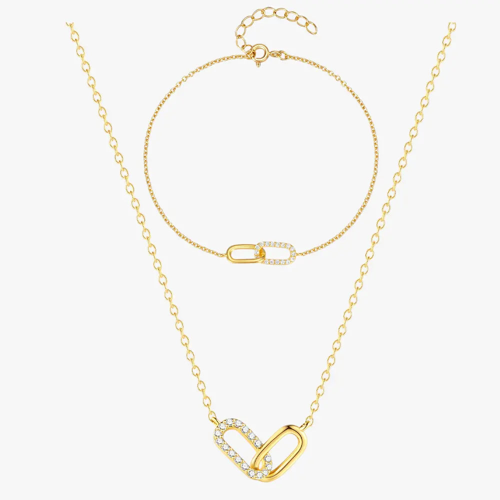 Beautiful gold crossover zirconia necklace and bracelet set, styled on a soft background with fine details.