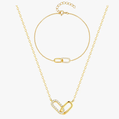 Beautiful gold crossover zirconia necklace and bracelet set, styled on a soft background with fine details.