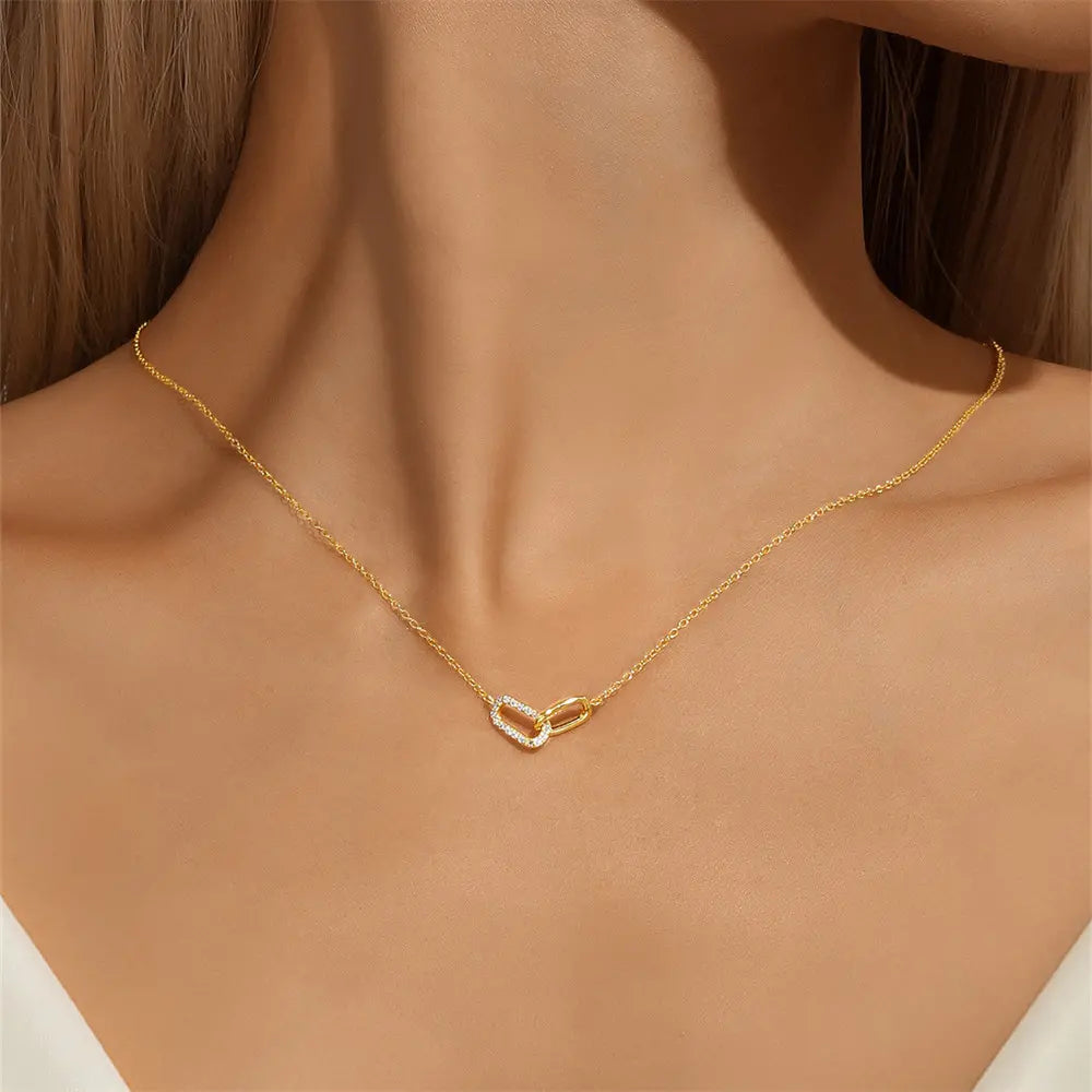 Model wearing a gold crossover zirconia necklace, adding elegance to their outfit.