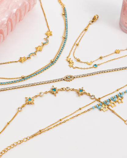 Gold and turquoise beaded necklaces on a white surface