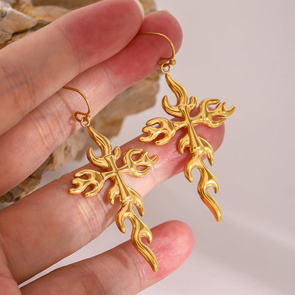 Y2K-inspired gold flame earrings displayed on stone surface