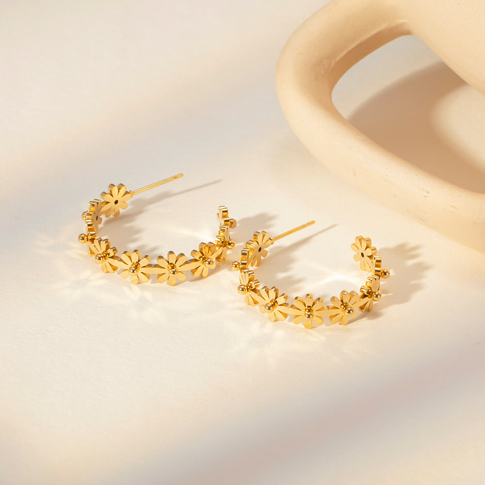 side and front view of gold flower earrings with daisy clusters forming a statement circle hoop