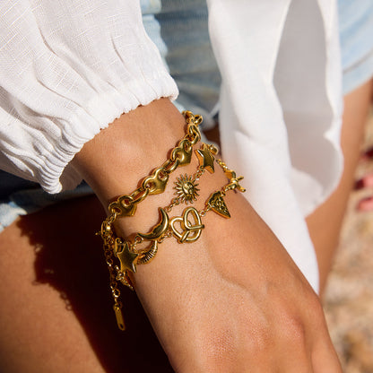 Sun-kissed close-up of charm bracelet with star, moon, pizza, and bow