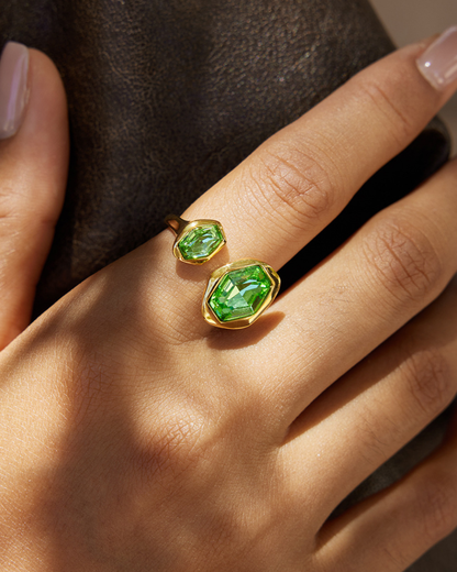 Gold rings with green gemstones on a hand
