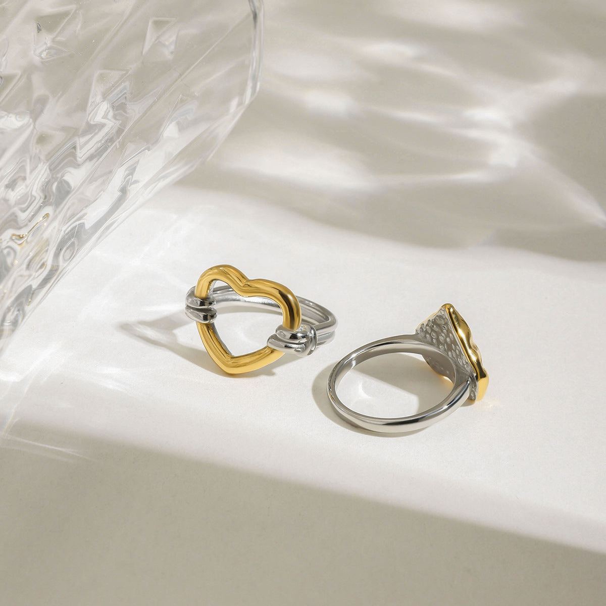 Gold hammered heart ring with silver band isolated on light background