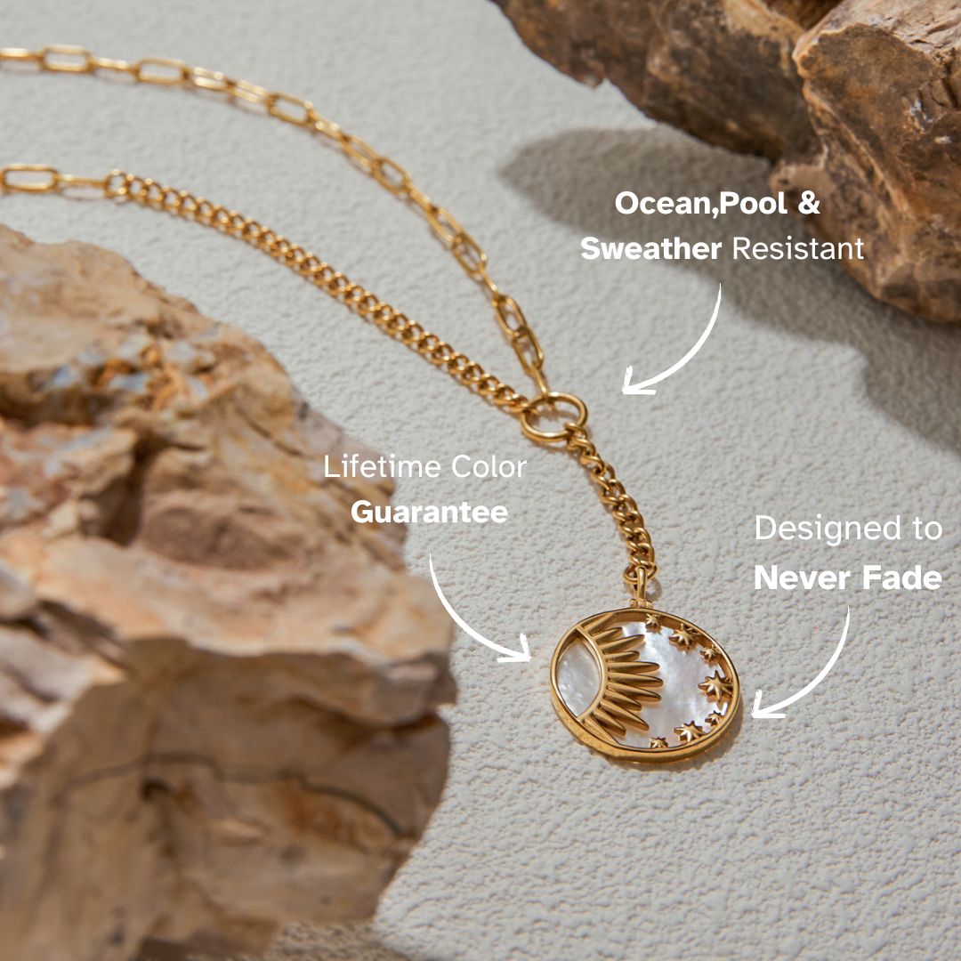 Golden Y-necklace with shell charm draped elegantly over rock