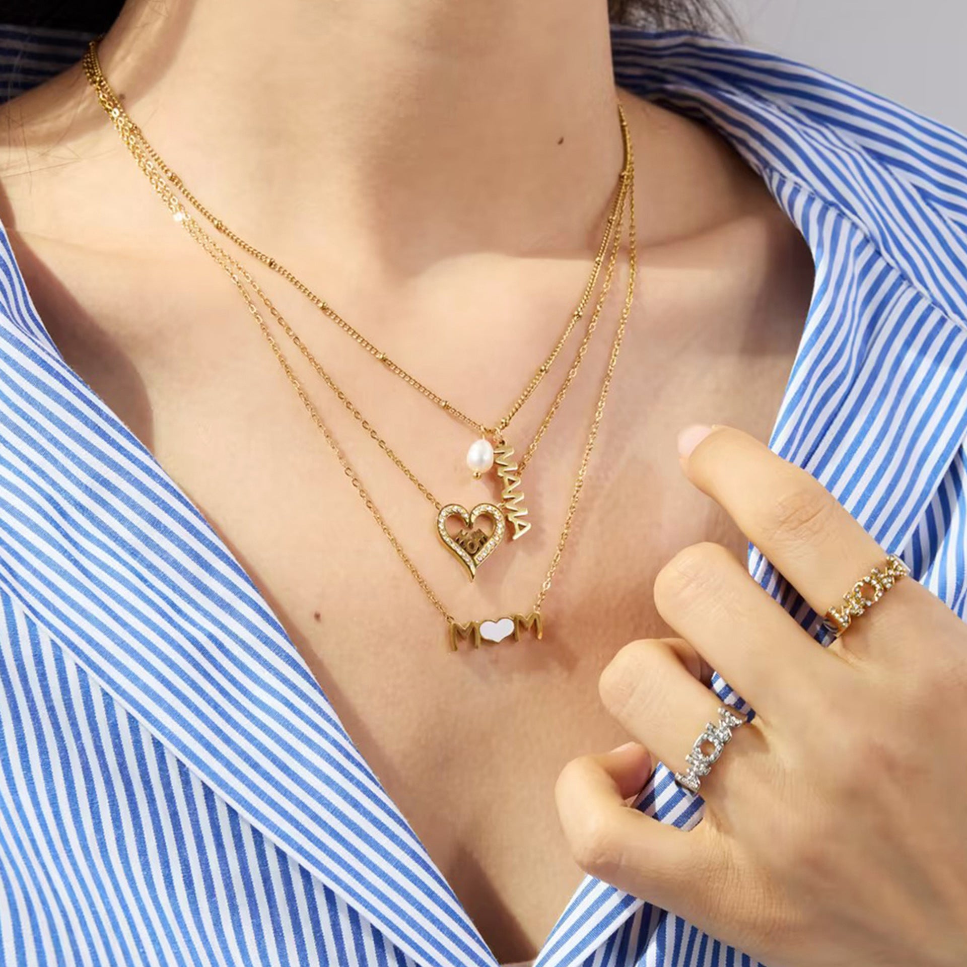Close-up of double mom rings and heart pendant necklace, gold and silver mix