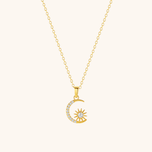 Dainty celestial charm necklace with moon and star on soft beige surface, minimal style.