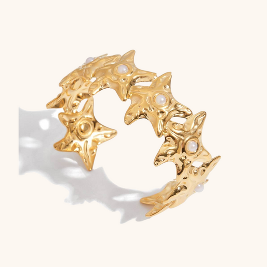 Elegant studio shot of the wide gold cuff adorned with glowing pearls in a floral burst arrangement, ideal for stylish women.
