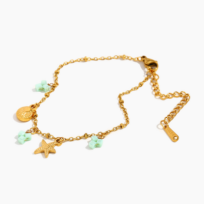 Gold bracelet with charms on a white background