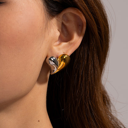 Model wearing mixed gold and silver heart earrings, close-up on ear and jawline