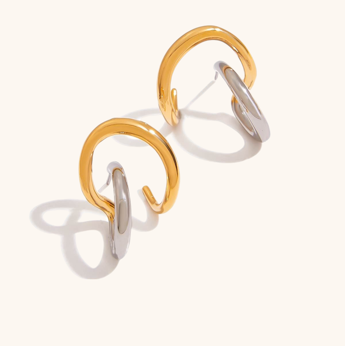 Product photo of mixed-metal open hoop earrings with intertwined gold and silver rings