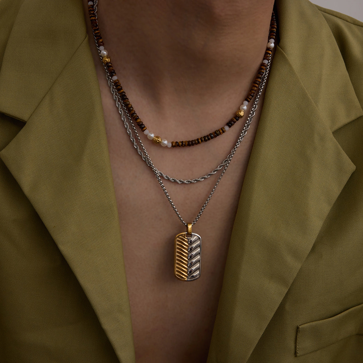 two-tone pendant necklace styled with layered chains on model