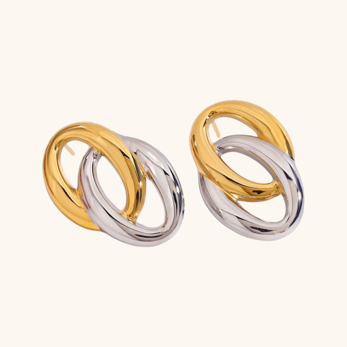 Two-tone gold and silver interlocked hoop earrings shown against cream background