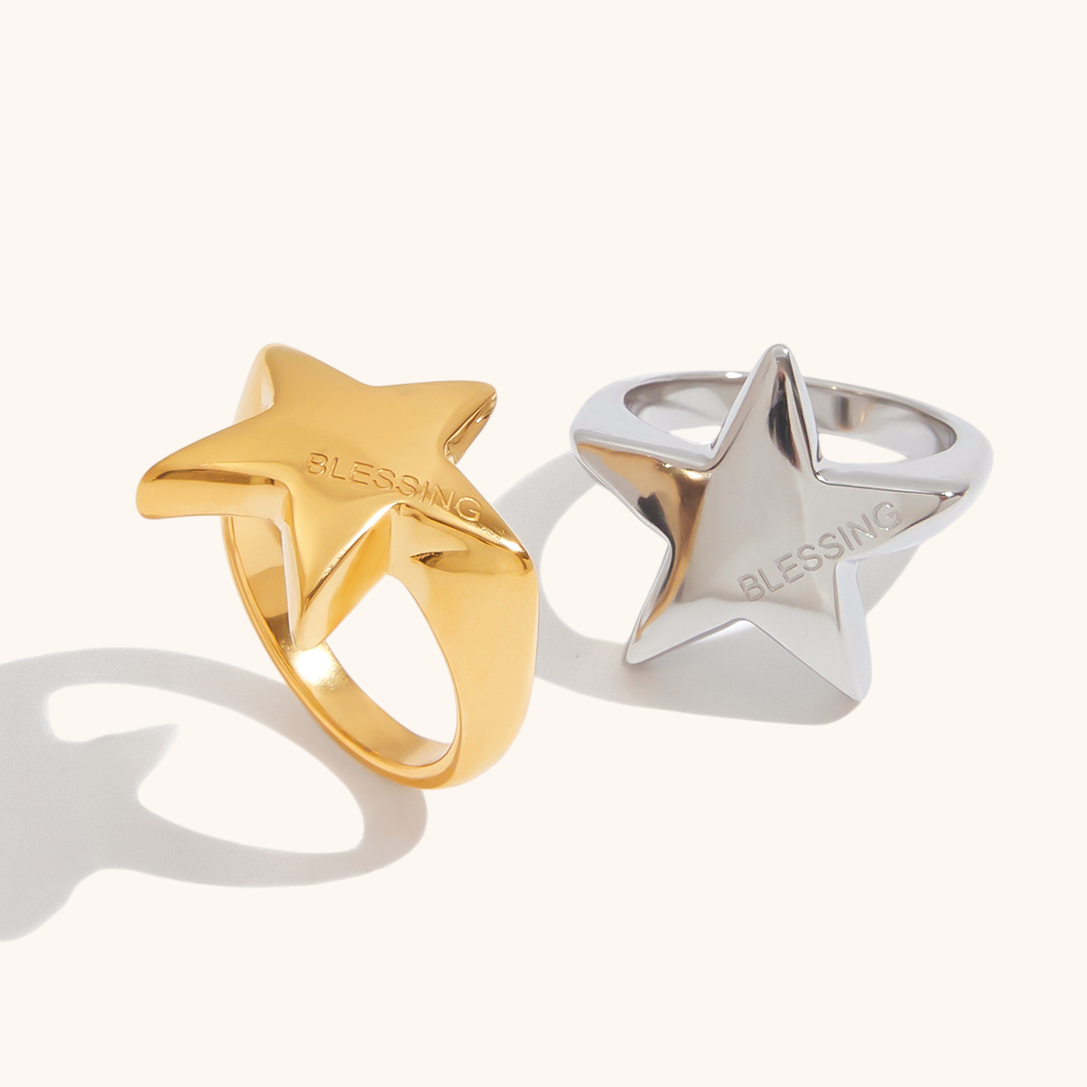 Close-up of gold star-shaped ring with engraved message, displayed solo on white backdrop