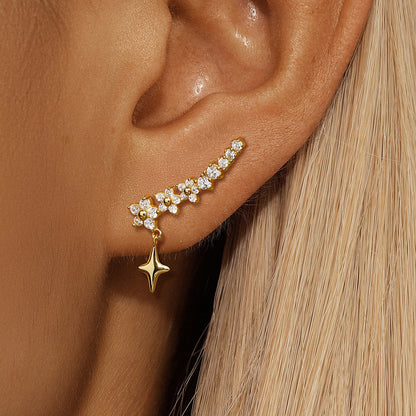 Blonde model wearing star drop earrings with cubic zirconia stones, styled with sleek hair.