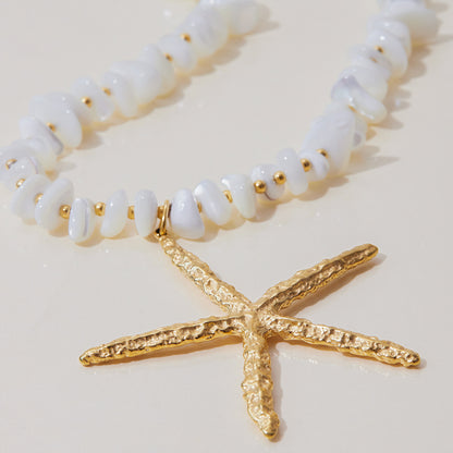 Detail of textured gold starfish pendant and organic white chips, designed for summer beach style