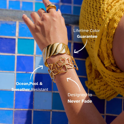 Close-up of polished gold cuff bracelet with elegant twisted texture, styled for summer resort outfit.
