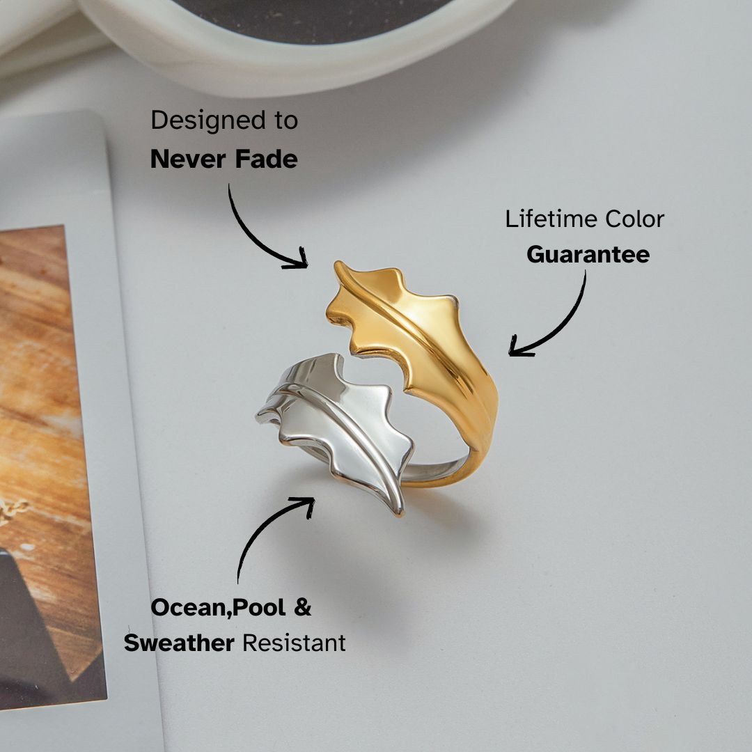 Dual leaf open ring placed next to fashion magazine and sunglasses