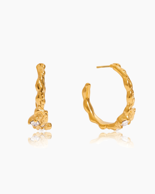 Gold hoop earrings with small stones on a white background