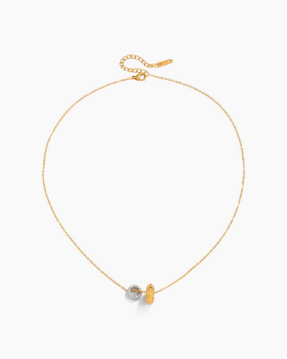 Gold necklace with a small pendant on a white background