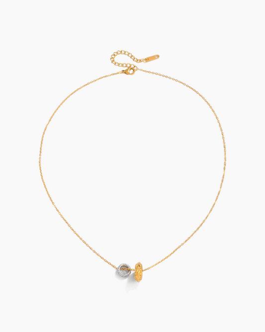 Gold necklace with a small pendant on a white background