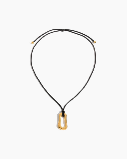 Black necklace with a gold pendant on a white background