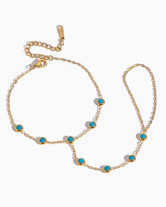 Gold necklace with turquoise stones on a white background