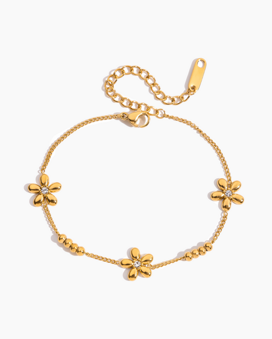 Gold bracelet with floral designs on a white background