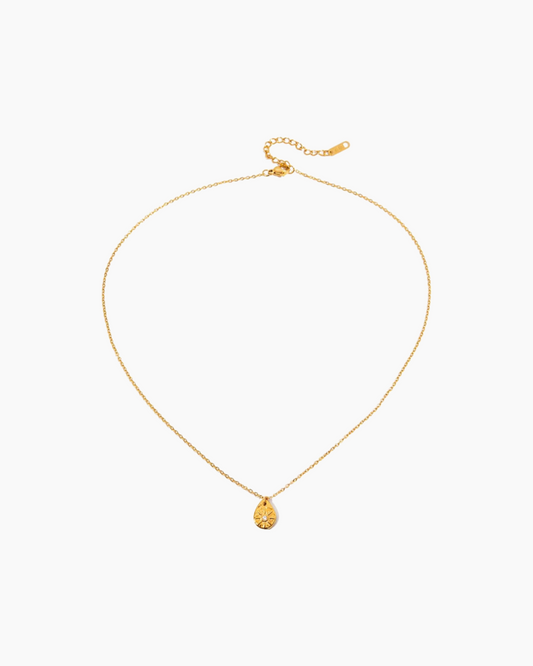 Gold necklace with a small pendant on a white background