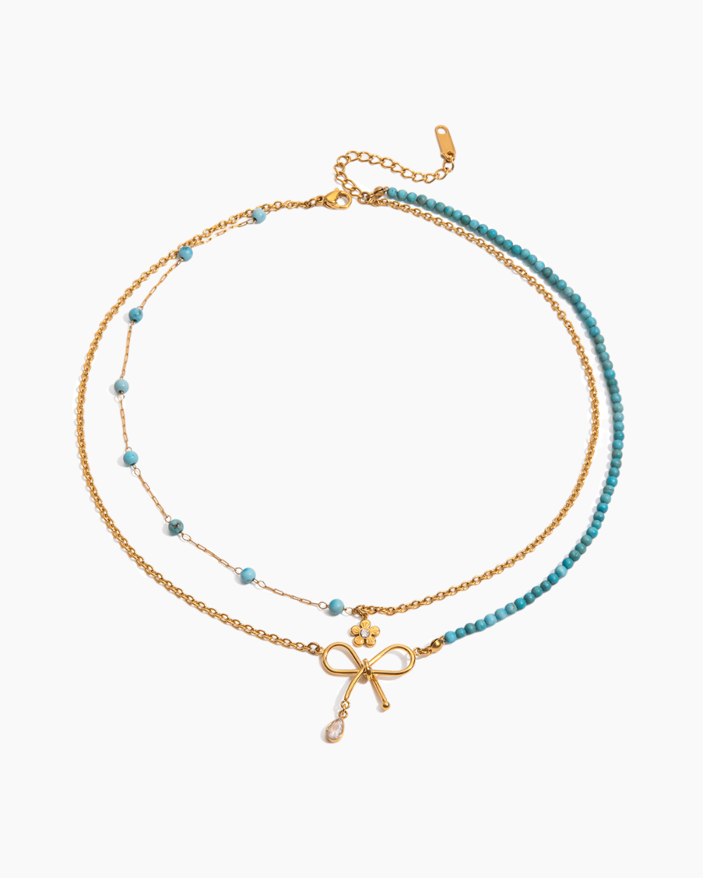 Two layered necklaces with bow and cross pendants on a white background