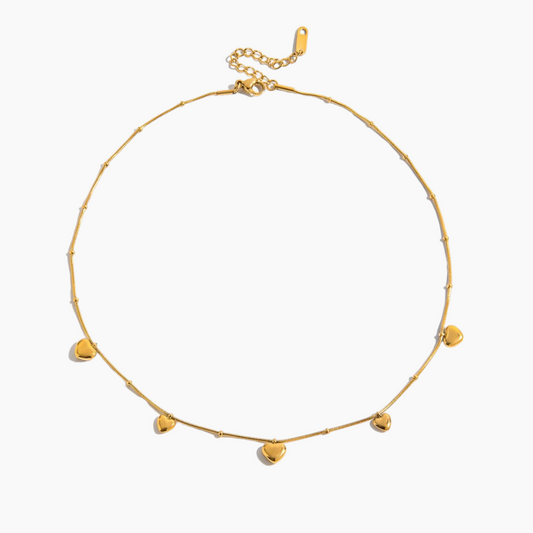 Gold necklace with heart-shaped pendants on a white background