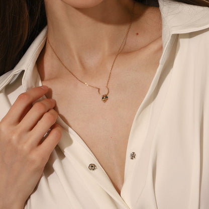 Side profile of model wearing a gold crescent necklace with delicate green details.