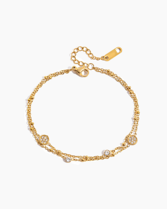 Gold bracelet with small crystals on a white background