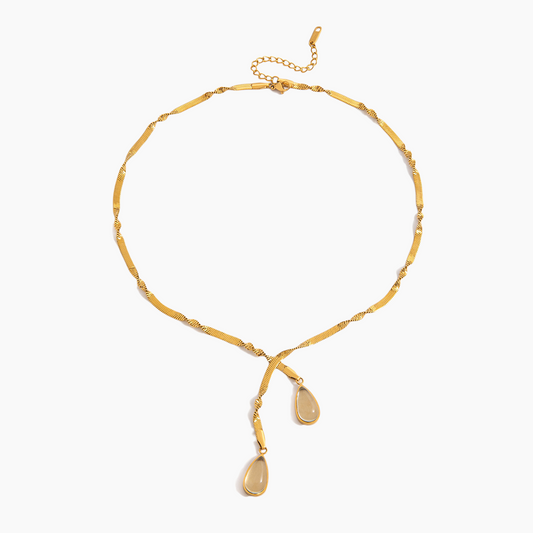 Gold necklace with teardrop pendants on a white background