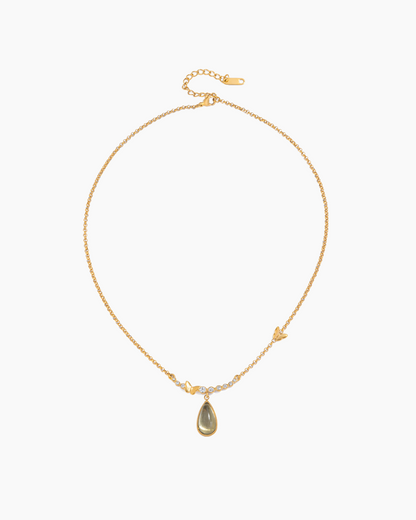 Gold necklace with a teardrop-shaped pendant on a white background