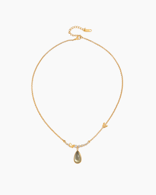 Gold necklace with a teardrop-shaped pendant on a white background