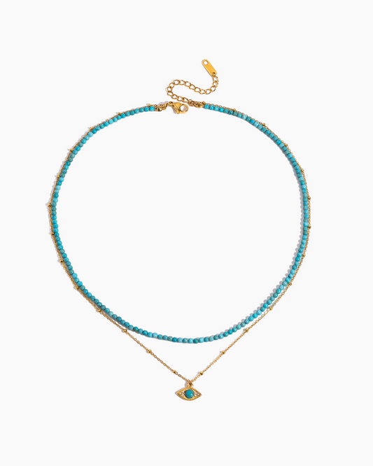 Turquoise beaded necklace with a gold chain on a white background