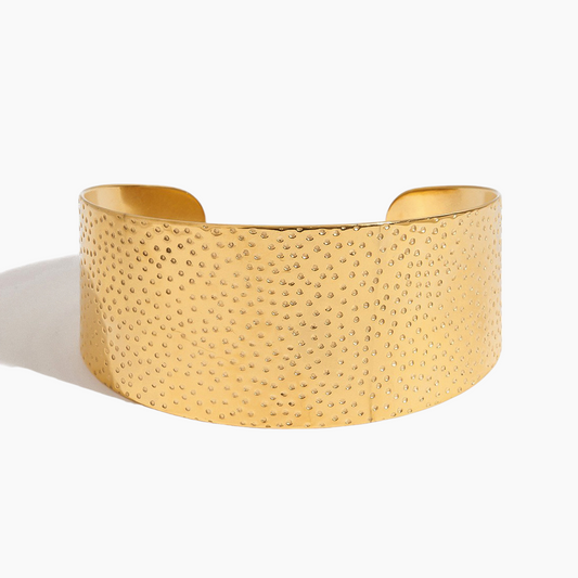 Gold textured cuff bracelet on a white background