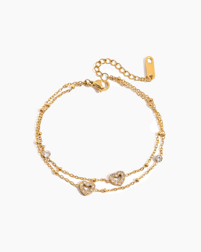 Gold bracelet with heart-shaped charms on a white background