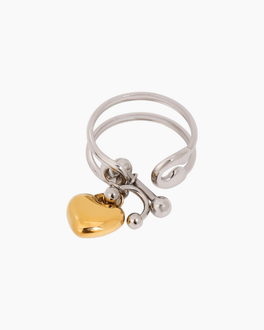 Silver ring with a gold heart charm on a white background
