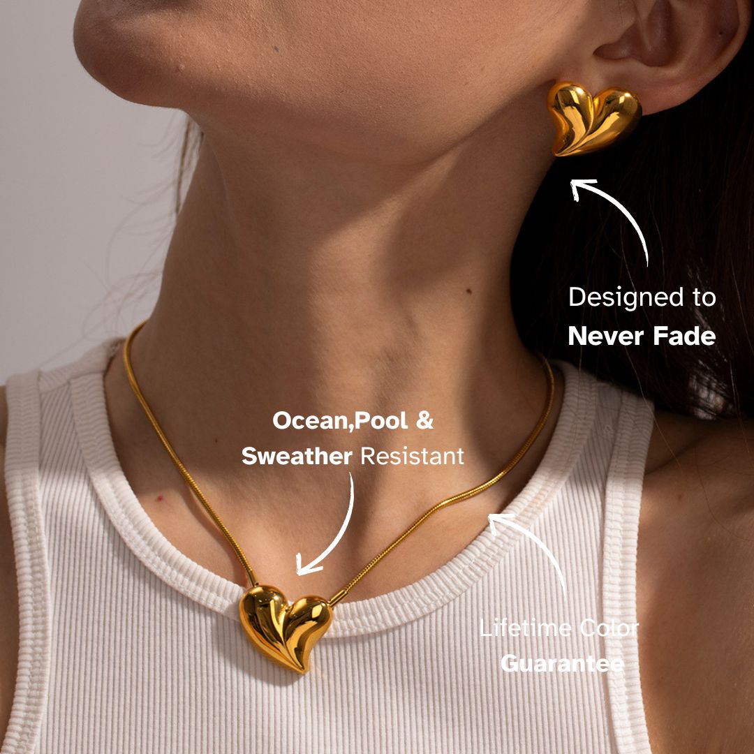 Model wearing heart-shaped gold earrings and matching pendant necklace — timeless waterproof pieces with lifetime shine guarantee