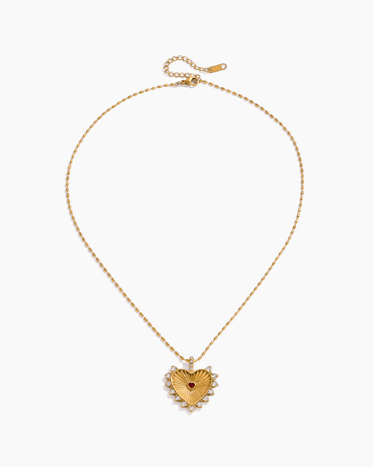 Gold necklace with a heart-shaped pendant on a white background