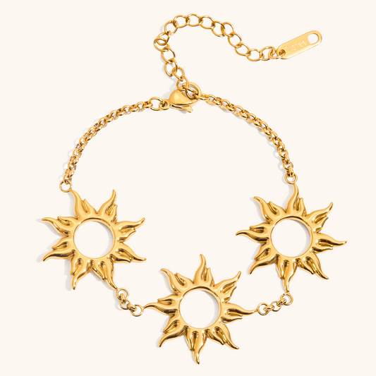 Flat lay image of gold triple sun charm bracelet with adjustable chain