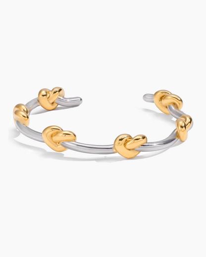 Two-toned ring with heart-shaped ends on a white background