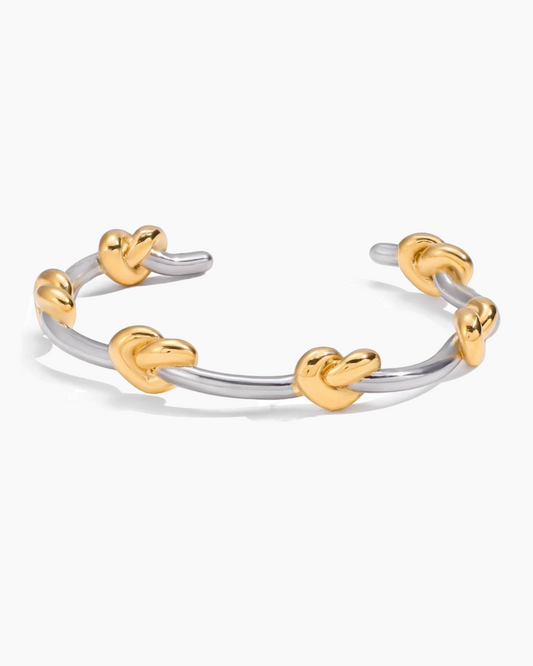 Two-toned ring with heart-shaped ends on a white background